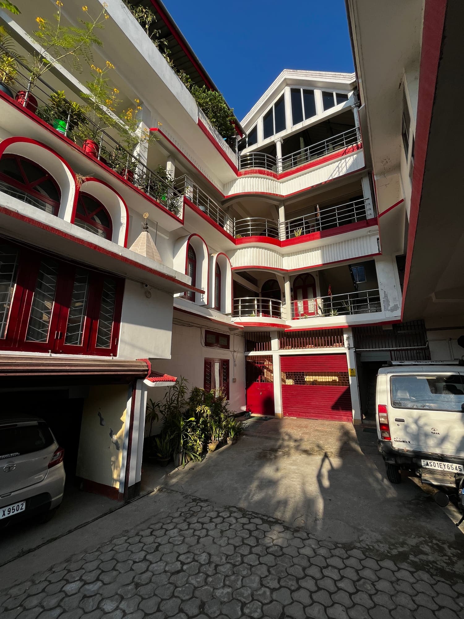 Paved courtyard driveway leading to the homestay's red and white wings