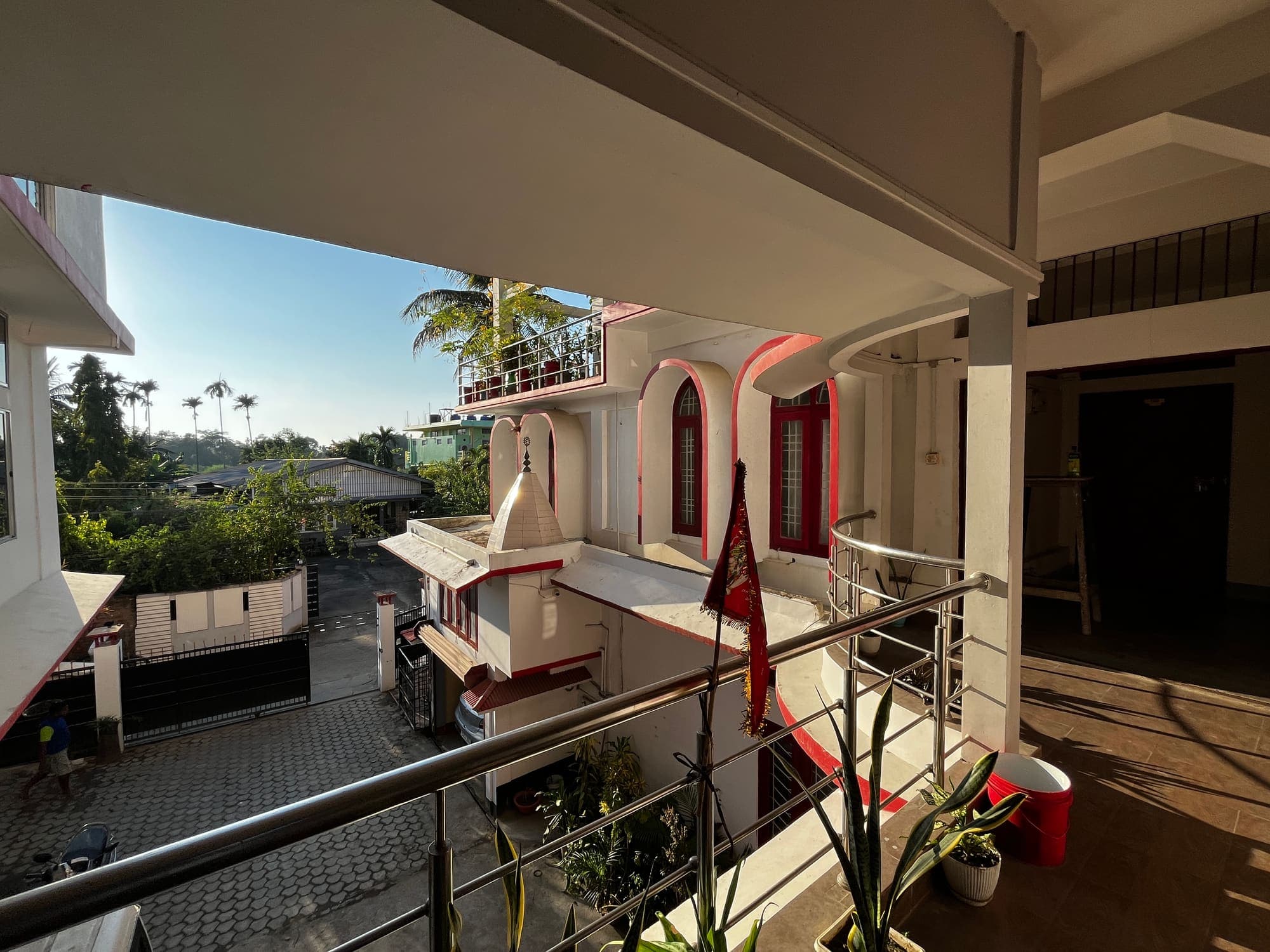 Upper balcony looking across the courtyard to the palm-lined neighbourhood